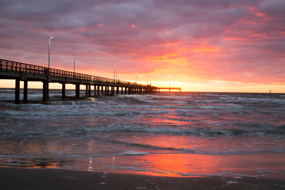 view of pier with sunset in the background