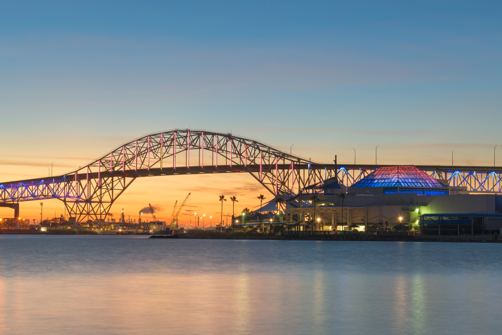 view of a bridge over water with sunset in the background