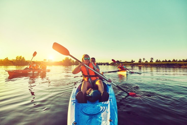 people kayaking in blue kayak with life jackets