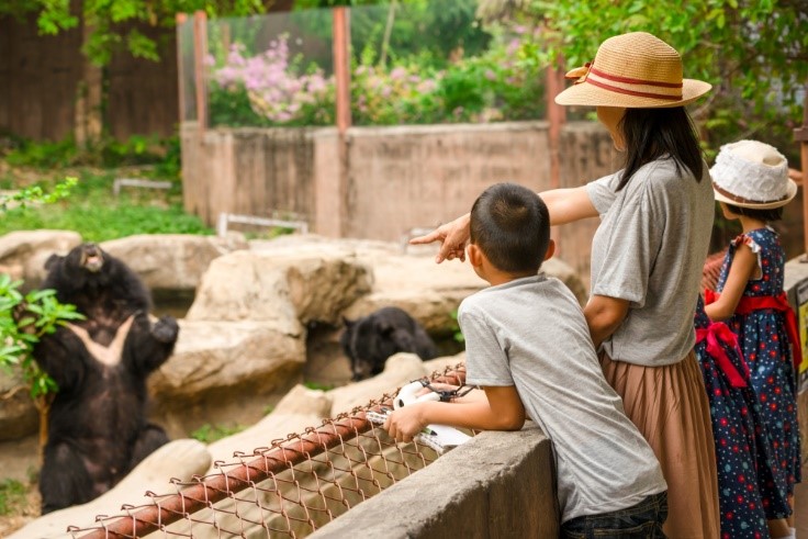 family at zoo with bear standing