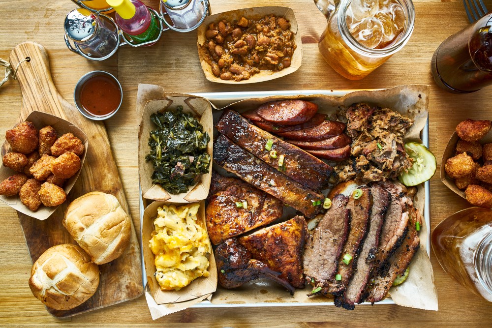 Texas BBQ on a wooden table with drinks and other various side dishes