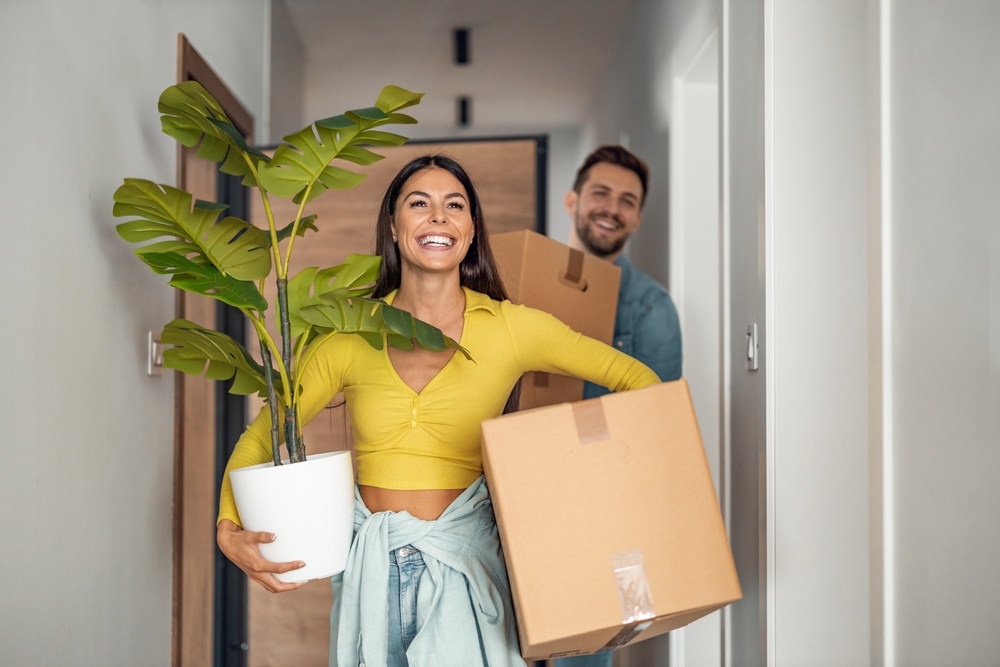 Young couple carrying out boxes as they move