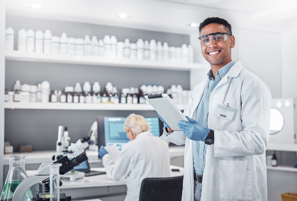 Scientist smiling and holding a tablet