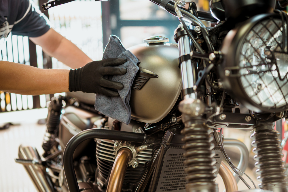 Person cleaning their motorcycle with a cloth