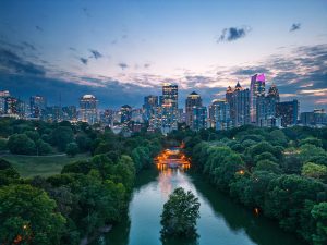 An aerial shot of the Atlanta skyline featuring parks and bridges in the foreground.