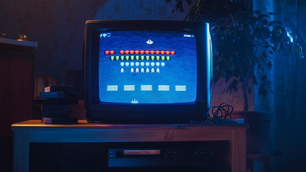 A vintage box TV set with a 70s style video game on it.