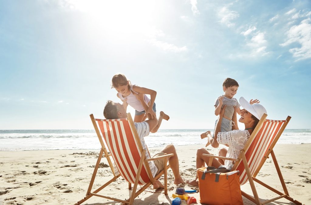 Parents and two children having fun on a beach.