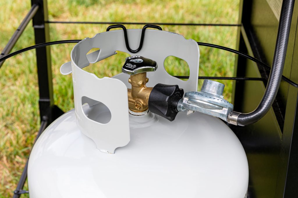 A propane tank attached to a grill.