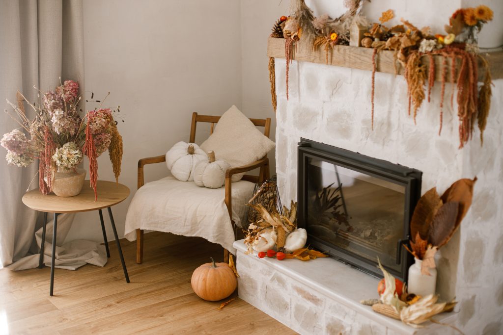 A fire place in a living room decorated for fall.