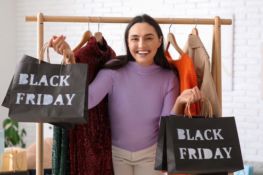 A smiling woman holding shopping bags with the text "Black Friday."