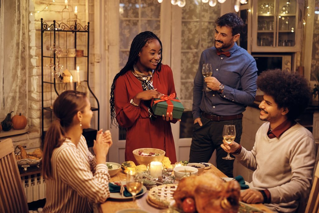 A group of friends gather around a table of food for Christmas