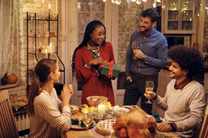 A group of friends gather around a table of food for Christmas