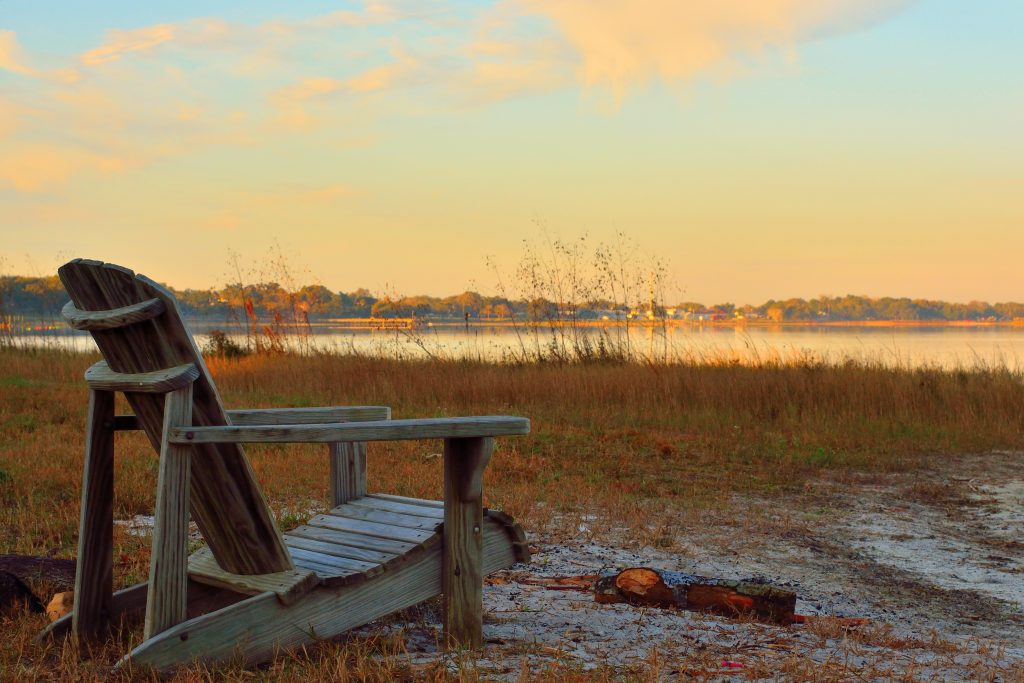 An Adirondack chair on the shore of Lake Minneola.