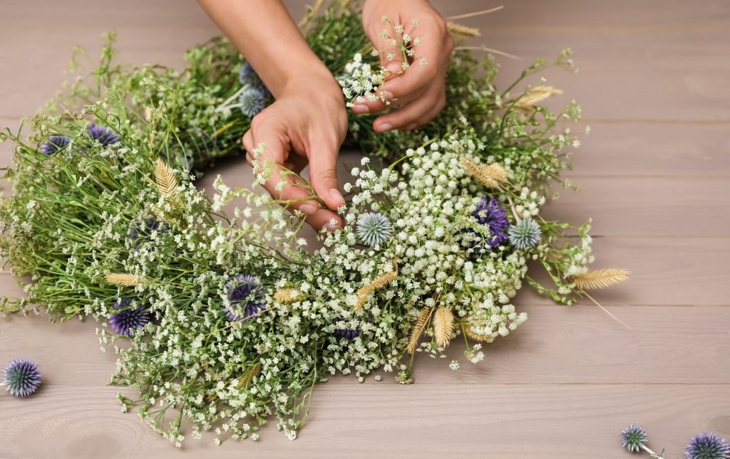 Hand making a floral spring wreath.
