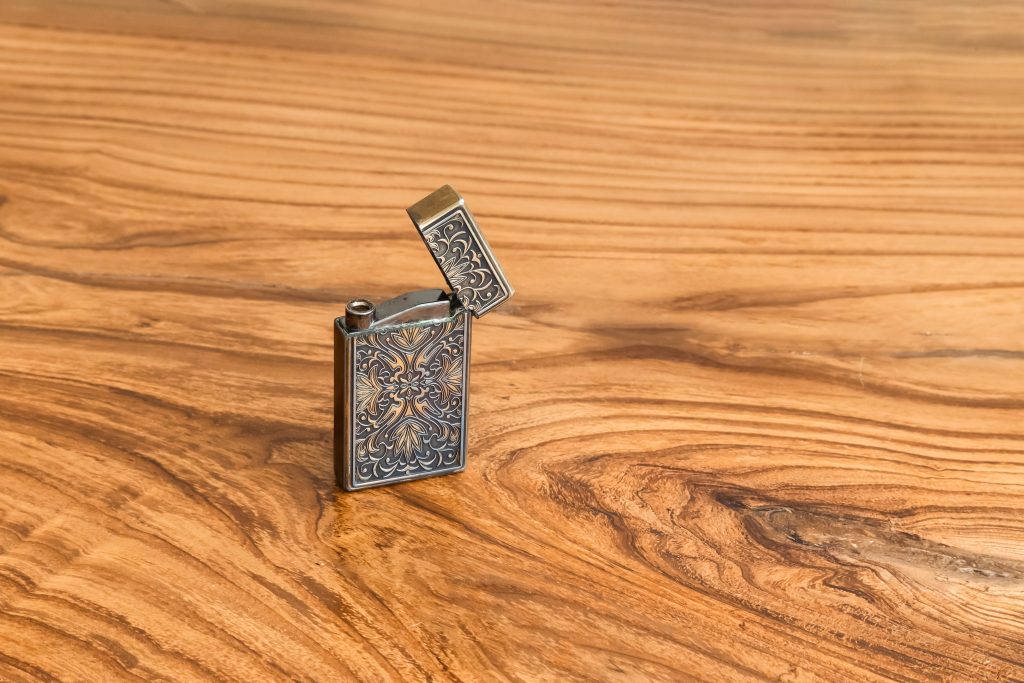 A vintage lighter on a wood table.