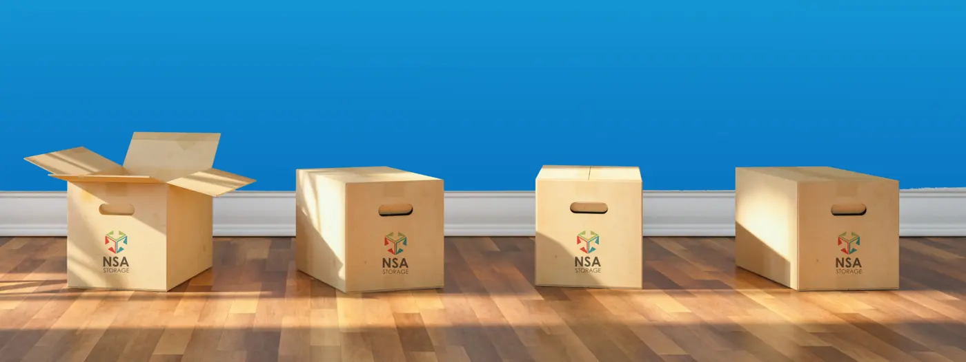 A smiling couple moving cardboard boxes into a new home.